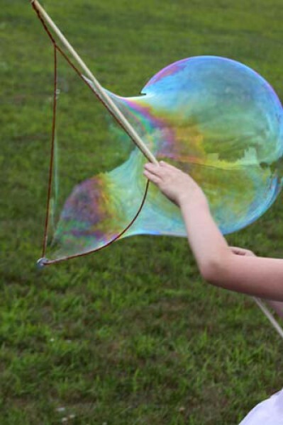 A large bubble being made with a dowel and string