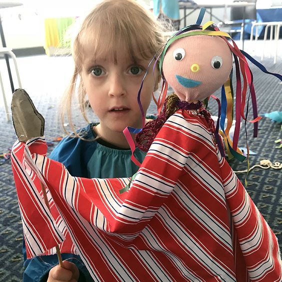 A little girl holding a handmade puppet